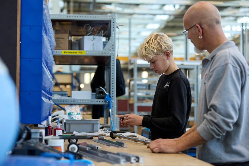 Jongen leert techniek van leraar in werkplaats.