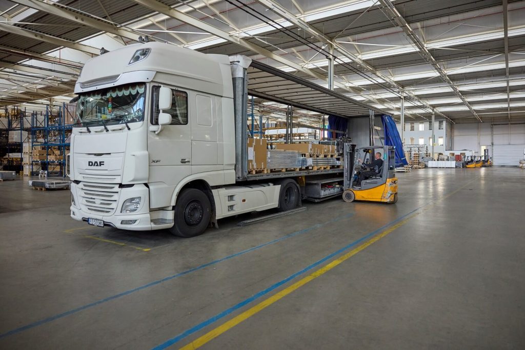 Vrachtwagen en heftruck laden goederen in magazijn
