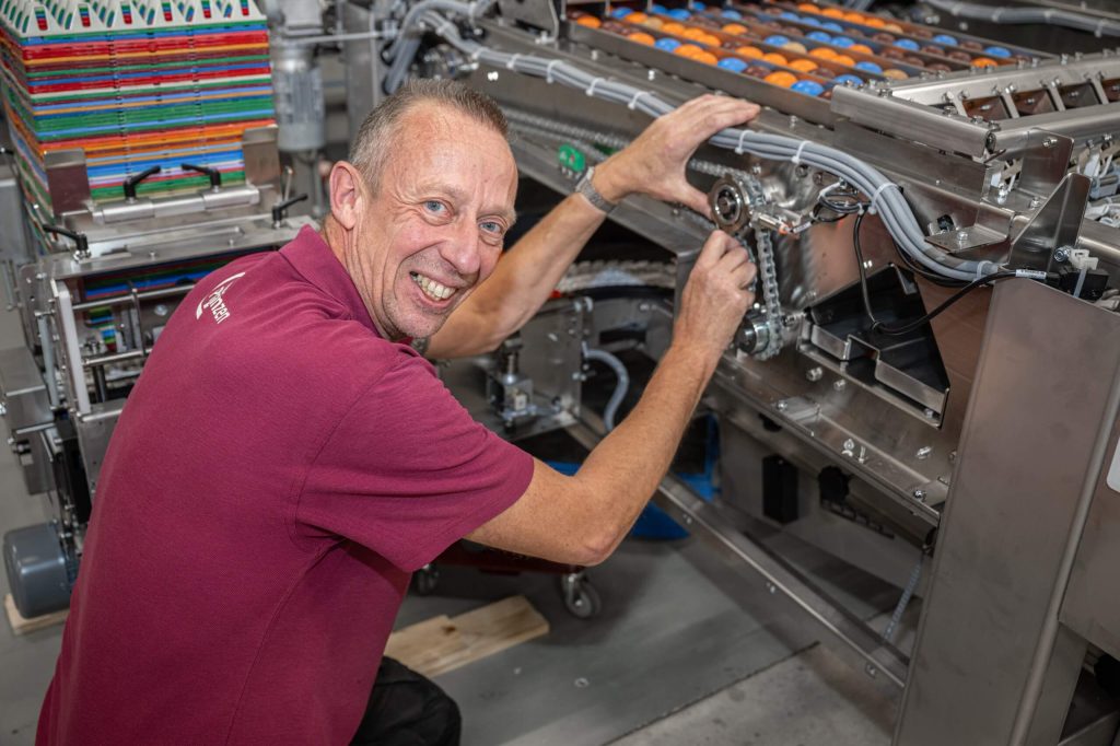 Man repareert industriële machine in werkplaats.